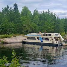 Kyle Skov Owatonna – Houseboat Moored by Shore